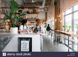 Hostesses Talking Looking At Seating Chart In Restaurant