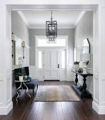 The bright white walls and doors are paired with stately modern farmhouse decor in light shades of wood and blue, which gives the area an airy, spacious feeling. Top 80 Best Foyer Ideas Unique Home Entryway Designs