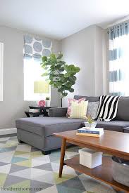 Gorgeous living room with light gray walls paint color, jonathan adler ventana 2 tier chandelier, marble fireplace surround, mirrored coffee table, oatmeal linen sofa & chair, khanjali ikat fabric pillows. How To Choose The Perfect Greige Paint Color For Your Walls