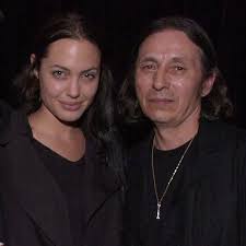 Angelina Jolie at a concert to celebrate the release of John Trudell's  album “Bone Days,” October 2001 John Trudell was romantically involved with  Angelina's mother, Marcheline Bertrand, and Angelina exec-produced his  album.