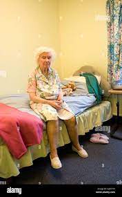 Unglücklich ältere Dame in Pflegeheim sitzen am Rande von Bed  Stockfotografie - Alamy