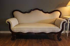 This sofa has a wooden frame and an upholstered seat, backrest, and armrests. Altes Biedermeier Sofa