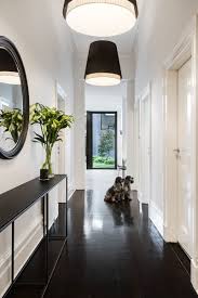 Instead of the hallway, the houses have a living room with a dining area and a staircase leading to the second floor. This Modern House Addition Showcases The Ceiling Height With Tall Windows