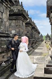 Dengan saling berpandangan tanpa berpelukan dengan latar cahaya matahari dipadu dengan pohon. Prewedding Psht Romantis Nusagates