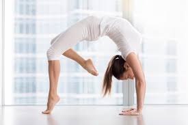 Mujer Atractiva Joven En La Postura De Urdhva Dhanurasana Contra La Ventana Del Piso Foto Gratis