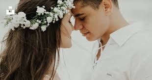 Woman in white dress shirt kissing mans cheek photo
