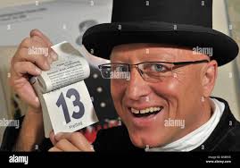 Looking astouned, chimney sweeper-master of the district Leipzig, Thomas  Zeitler, holds the calender sheet indicating Fiday the 13th into the  camera, Germany, 12 August 2010. Zeitler faces This Friday calmly and will