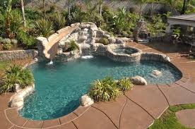 Beige Tiles Grey Stones And Green Plants Lining The Sides Of A Small Pool Containing A Slide Like Decorative Backyard Pool Water Slides Backyard Small Backyard