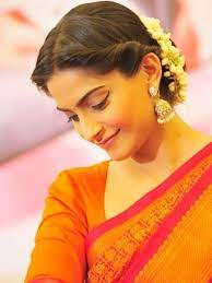 3 Middle Parted Twisted Bun With Mallige Huvu In Hair Indian Wedding Hairstyles Indian Hairstyles Engagement Hairstyles