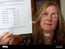 Leslie Robison holds up a credit card statement showing the fraudulent  billings while she peaks about her experience with credit card fraud that  she's Stock Photo