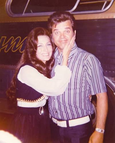 Loretta Lynn and Conway Twitty goofing around outside of her tour bus  (early '70s). 🎶