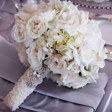 White Tea Rose Bouquet With Pearl Seed Embroidered Lace Wrap And Antique Brooch Muted Periwinkle Satin Table Gorgeous Wedding Bouquet Wedding Bouquets Wedding