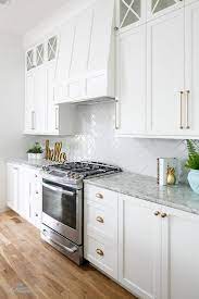 We will be using a lot of white in our space along with pops of gold and natural brass, though our cabinet colour is a lighter grey than this quite dramatic charcoal tone. White Kitchen Cabinets With Champagne Gold Hardware Transitional Kitchen