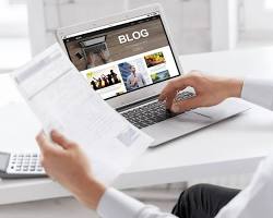 person writing a blog post on a laptop resmi
