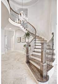 Lovely Entryway With Chandelier Lighting Spiral Wooden Stairs And Wall Art Find More On Ho Home Remodeling Contractors Staircase Design Home Interior Design