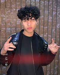 The short, light brown hair curls parted sideways worn with spectacles black curly hair styled with layers and a center parting left open. Pin By On Giovanny Boys Curly Haircuts Boys With Curly Hair Boys Haircuts