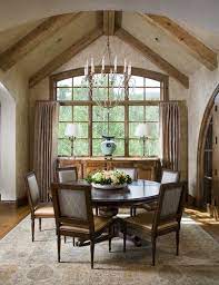 Classic windsor chairs hug a long wood table in an expansive dining room that doesn't feel large or cold. 13 Cozy And Inviting Country Style Dining Rooms