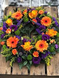Florists in grand rapids mn love this funeral basket filled with vibrant colors of flowers to make their life made up of roses, spray roses, gerberas, alstroemeria and more in shades of red, orange, yellow, pink and. Vibrant Orange Gerbra Purple Wreath Funeral Flowers Vanilla Blue Flowers