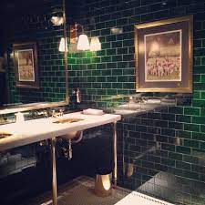 A black light in a bar bathroom sounds frightening in most cases, but, somehow, royal jelly makes it work. Green Is Good Habitually Chic Green Tile Bathroom Restaurant Bathroom Bathroom Inspiration