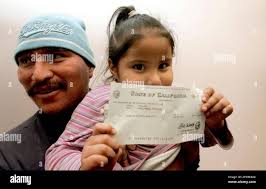 Litzy Ortiz, 4, holds a $2,688 check her father Carlos Orellana received  Wednesday, Oct. 26, 2005, in Los Angeles after he learn of the unclaimed  money. State Controller Steve Westly is kicking