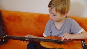 For those who have never played one before, knowing where to even then try some simple upwards strums, noticing how they feel a little different. Little Kid Playing On Guitar Stock Footage Video 100 Royalty Free 12315449 Shutterstock