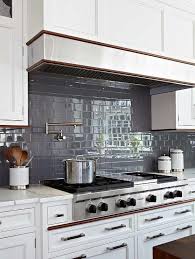 Dark Gray Subway Tiles Continue Throughout A Kitchen Backsplash Around White Shaker Cabinets Accented W Gray Kitchen Backsplash Kitchen Renovation Grey Kitchen