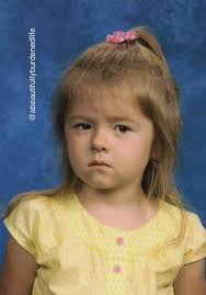 Her teacher held the oversized envelope tightly against her chest. She  grimaced and said “I'm sorry” upon handing me the packet containing my  daughter's first-ever school pictures. “Retakes are next month,” she