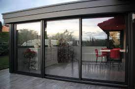 extension veranda vitree donnant sur terrasse a carrelage gris imitation parquet deco windows