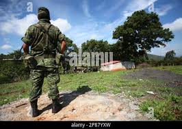 A Mexican soldier stands guard in front of a charred auto in front of the  Piedras Negras City Hall and jail, Dec. 31, 1984, after supporters of a  defeated mayoral candidate set
