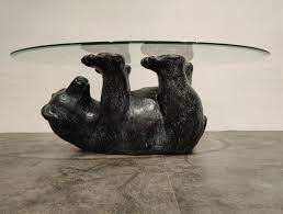 Black forrest bronze bear coffee table realistically cast and modeled of a bear on his back supporting the oval glass top with his four legs. Unique Sculptural Black Bear Coffee Table 1970s 154746