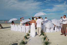 White Umbrellas For Shade At At Beach Wedding In New Smyrna Beach Florida Destination Wedding Beach Wedding Photography Beach Wedding New Smyrna Beach