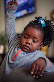 Mujer con sudadera con capucha gris besando perro marrón y blanco foto