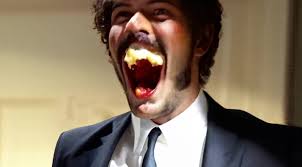 Prompt: "The man lowers his weapon and instead grabs a burger and eats,  showing a big smile because the burger is super sloppy and delicious."