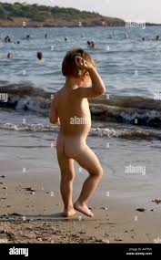 Kleiner Junge nackt nackt nackte spielen oder an einem Strand am Meer in  Griechenland Stockfotografie - Alamy