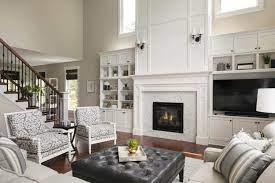 A living room with a fireplace and tv on the same wall Two Story Woodbury Living Room Fireplace Design Ispiri Projects