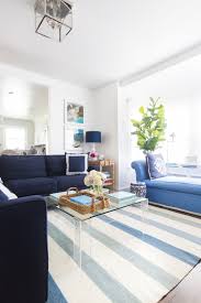 A console styled with dramatic greens and your favorite coffee table books make a fresh arrangement. Our Living Room Reveal Design Darling