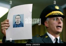Police officer in Lancaster, Pennsylvania stands behind yellow police  cordon tape after a bank robbery Stock Photo