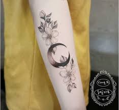 The moon is brightly colored with floral shapes and a single star hangs in the center. 20 Moon Tattoos That Are Simply Magical Cafemom Com
