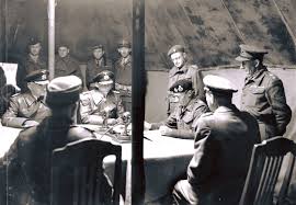 On 4 May 1945, Field Marshal Bernard Montgomery is pictured reading and signing the terms of the Instrument of Surrender of German forces in North-West Europe to the German delegation in an