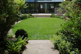Oval Shaped Lawn With Large Borders Around The Kids Play Area Is Half Hidden At The Rear Lawn Design Landscaping Inspiration Family Garden