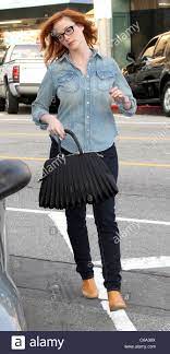 Christina rene hendricks was born in knoxville, tennessee. Christina Hendricks Unterwegs Mit Einem Ubergrossen Schwarze Handtasche Und Engen Jeans Cowboy Stiefel Und Ein Jeanshemd Los Stockfotografie Alamy