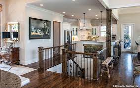 An Art Niche In The Kitchen Island Creates A Focal Point For The Stair Case The Monarch Manor House Plan 504 Stairs In Kitchen Kitchen Floor Plans Open Stairs