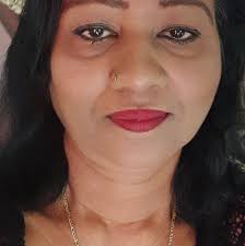 The image shows actor Mahesh Babu and his wife Namrata Shirodkar posing  beside a portrait of Mahesh Babu's late father, veteran Telugu actor  Krishna, during a memorial event or tribute. The event