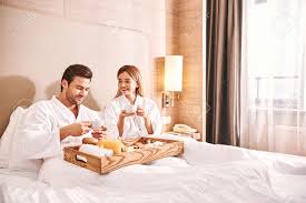 Food Delivery In The Room Couple Are Eating In Hotel Room Bed Stock Photo Picture And Royalty Free Image Image 117063611
