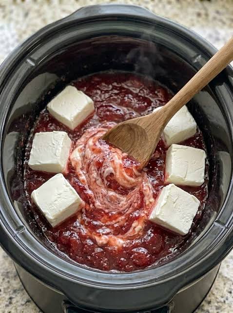 Swirling cream cheese and strawberry preserves in the slow cooker, AI generated