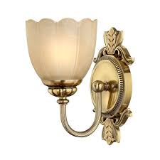 Its clear round glass shades extended from the antique gold arched arms contribute to the timeless beauty of this fixture. Traditional Bathroom Wall Light In Brass With Amber Etched Glass Shade
