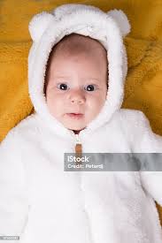 Little Baby In White Bear Costume On Yellow Blanket Stock Photo