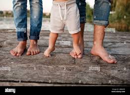 Nackte Füße der Familie. Holzbrücke. Mutter, Vater und Baby gehen nackte  Füße auf die Holzbrücke. Fröhliche junge Familie, die Zeit zusammen  verbringt. Das Konzept von Stockfotografie - Alamy