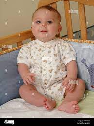 A Four Month Old Baby Sits Up In His Crib Stock Photo Alamy