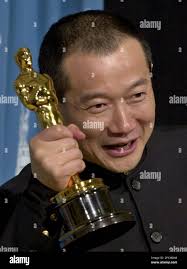 FILE ** Tan Dun shows off his Oscar for best original score for "Crouching  Tiger, Hidden Dragon," at the 73rd annual Academy Awards, in Los Angeles,  in this March 25, 2001